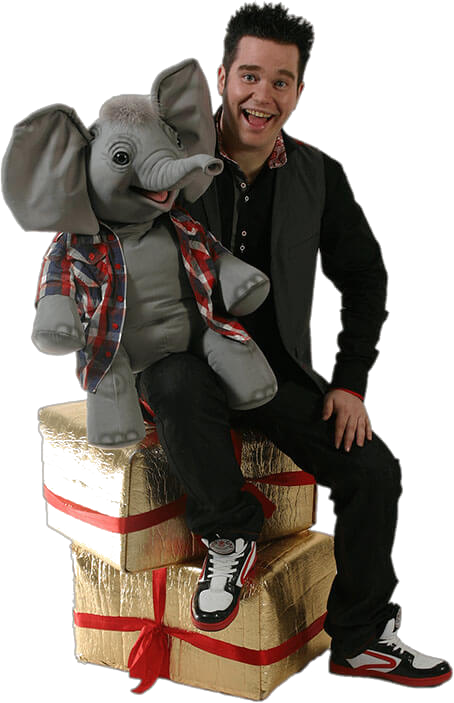 JJ the children's entertainer with his elephant puppet sitting on gift boxes