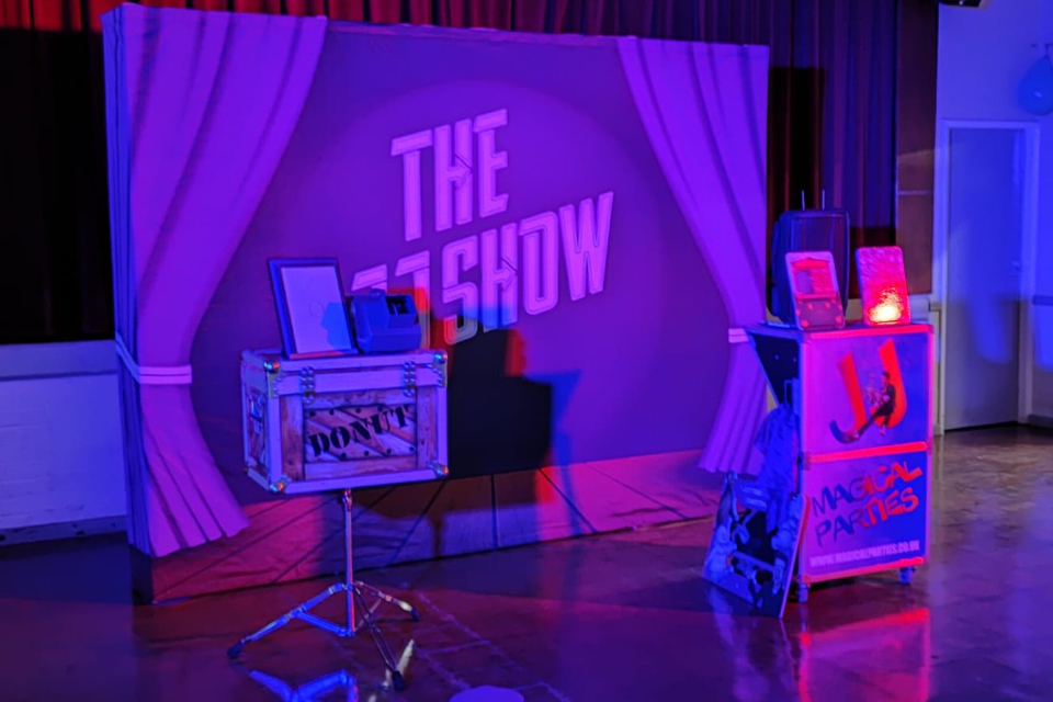 The JJ Show stage setup with purple backdrop, props and Magical Parties equipment
