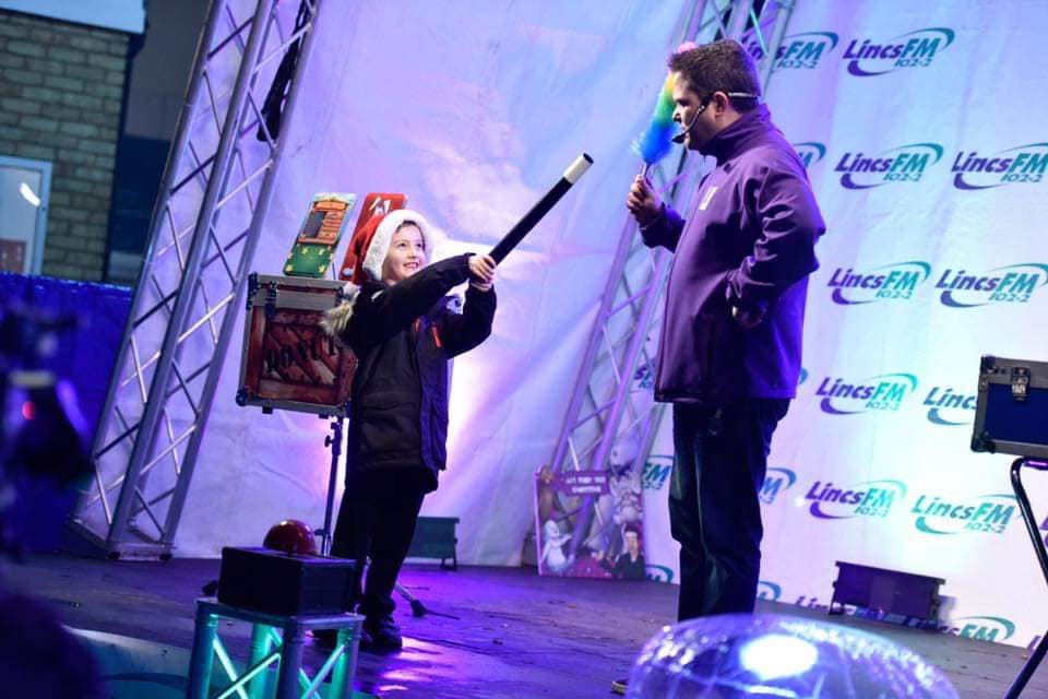 JJ performing a magic show on stage for families