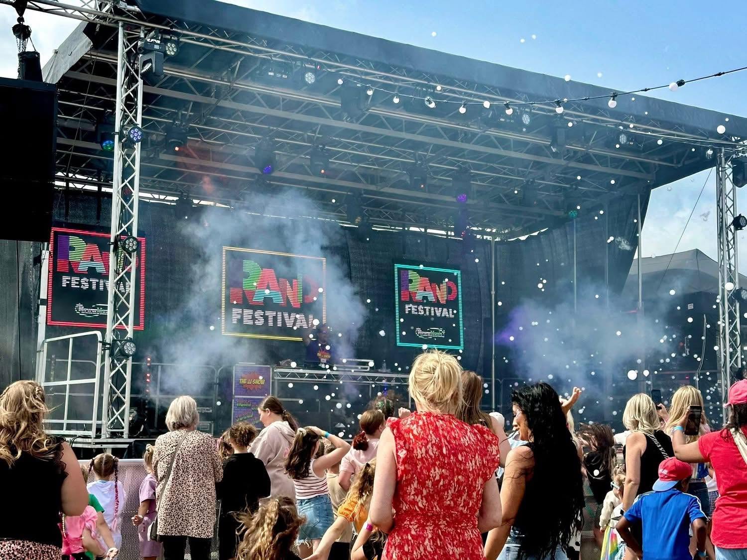 Families watching JJ's festival magic show outdoors